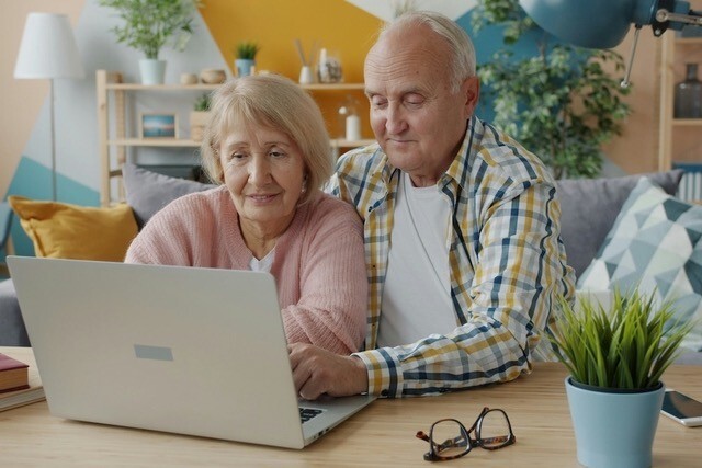 Oud stel achter laptop